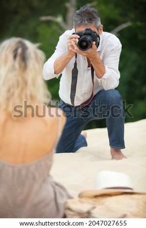 photographer taking picture of model on the beach