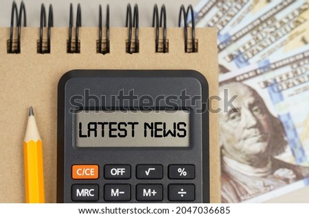 Business and finance concept. On the table there are dollars, a notebook and a calculator with the inscription - LATEST NEWS