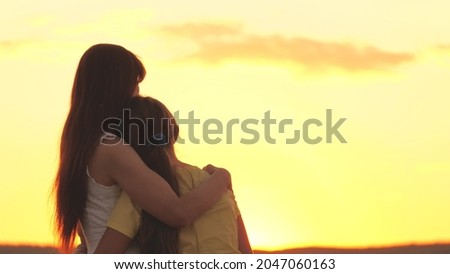 mother hugs and regrets her daughter against the backdrop of the sunset sky, love children, difficult age of teenager, take care of child's mental health, be attentive and kind, care and compassion Royalty-Free Stock Photo #2047060163