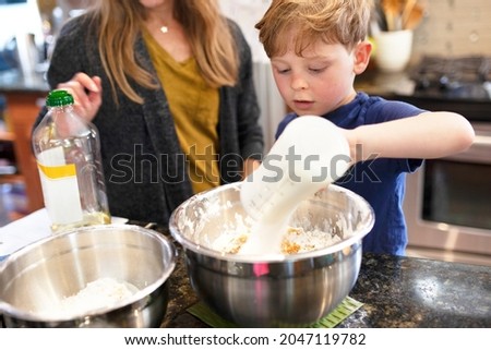 Kid learning how to bake with mom education photo