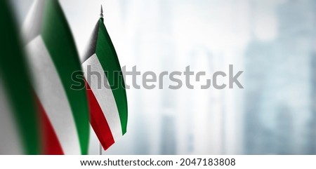 Small flags of Kuwait on a blurry background of the city Royalty-Free Stock Photo #2047183808