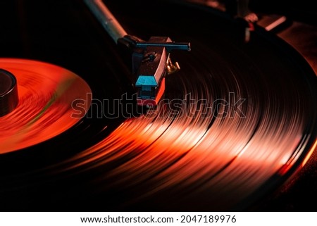 Needle detail on vinyl record on turntable, low light image with reflection Royalty-Free Stock Photo #2047189976
