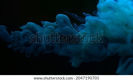 Beautiful abstract background. Blue-green watercolor paints in water on a black background. Chic wallpaper for your desktop. Creative hyptonic background. Blue-green cloud of ink on a black background