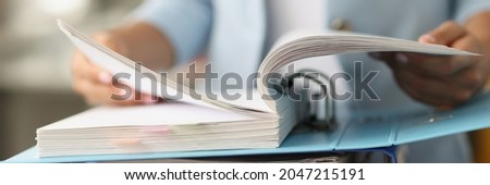 Woman examining information in folder with documents closeup Royalty-Free Stock Photo #2047215191