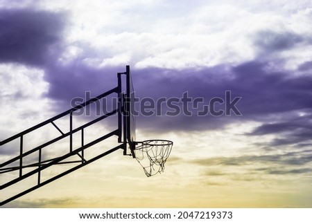 basketball basket in outfield with sunset sky background