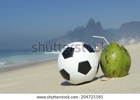 Fresh green drinking coconut coco gelado next to football soccer ball Ipanema Beach Rio de Janeiro Brazil