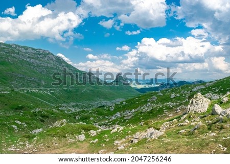 Mountains peaks  of the Durmitor National Park, along which picturesque high-mountain tourist road of northern Montenegro passes. UNESCO World Heritage site. Beautiful summer cloudy landscape.