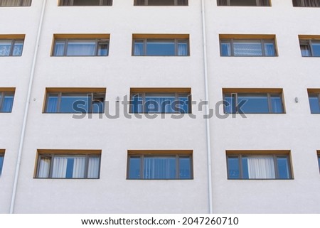 Glass windows reflecting the blue sky on modern apartment building.