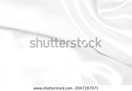 White cloth texture background. Close up abstract fabric for wallpaper or graphic design. Smooth silk that looks simple and elegant in vintage style. The surface has a beautiful wavy pattern.