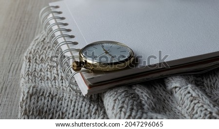 Vintage clock on a notepad. White list. Celebration atmosphere. Warm colors, soft focus.