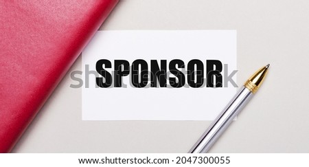 On a light gray background, there is a golden pen, a burgundy notebook and a white blank card with a place to insert text SPONSOR. Business concept. Template