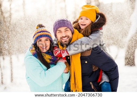 Photo of cheerful family mom dad daughter piggyback happy positive smile fly air snow winter nature outdoors