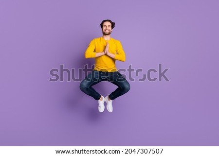 Full length body size photo smiling man in casual outfit jumping up practising yoga isolated pastel purple color background