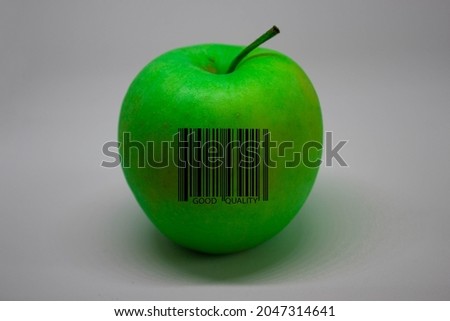 A green apple with a bar code saying GOOD QUALITY on white background.