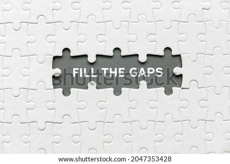 Top view of an empty space of jigsaw puzzle fill with a phrase Fill The Gaps. Royalty-Free Stock Photo #2047353428