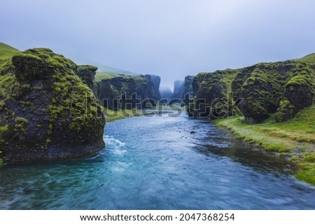 The famous and unique Fjadrargljufur valley in Iceland on a rainy day. Mossy cliffs and mountain river. Point of interest for tourists coming to visit Iceland Royalty-Free Stock Photo #2047368254