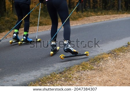 A woman on a roller ski rides in the park.Cross country skilling.