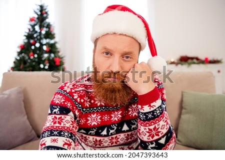 Photo of young unhappy negative mood tired man wear santa claus headwear hate new year christmas at home house Royalty-Free Stock Photo #2047393643
