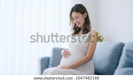 Young pregnant woman relaxing in the room Royalty-Free Stock Photo #2047482188