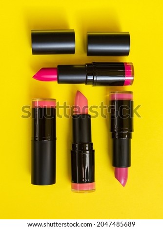 bright lipsticks lie on a yellow background