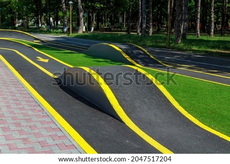 Element of a bike path with slides in a public city park. Trail for bicycles and skateboards. Extreme road for roller skates. Skatepark in an urban environment. Background
