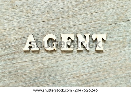Alphabet letter in word agent on wood background