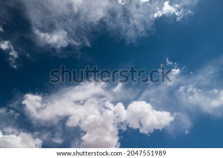 Blue sky with puffy white clouds. Dreamy fleeting thoughts concept. 