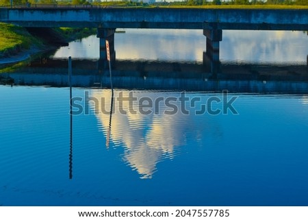 beautiful blue sky reflecting in the water of the drainage canals in the swamp