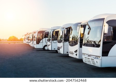Tourist buses on parking at sunrise or sunset. Royalty-Free Stock Photo #2047562468