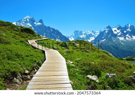 Wooden walkway in the mountain landscape. Nature Reserve Aiguilles Rouges, French Alps, France, Europe.