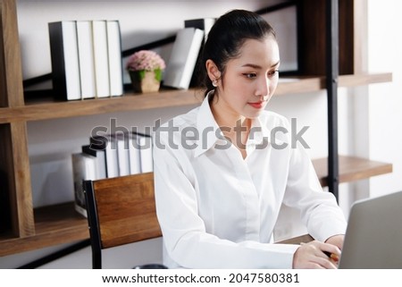 Asian manger businesswoman or secretary operator is researching and working with laptop at office. Collegian is studying knowledge in library at the university. Business and education with technology. Royalty-Free Stock Photo #2047580381
