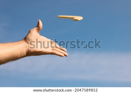 Man throwing boomerang against blue sky, closeup Royalty-Free Stock Photo #2047589852