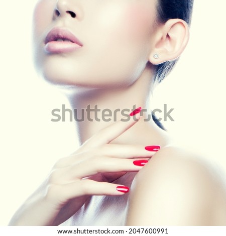 Lips. Close-up face and hand of beautiful woman over beige background touching her neck. lips with natural beige lipstick makeup