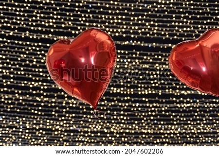 Copper heart shape balloons bunch on a black wall background. Horizontal banner.