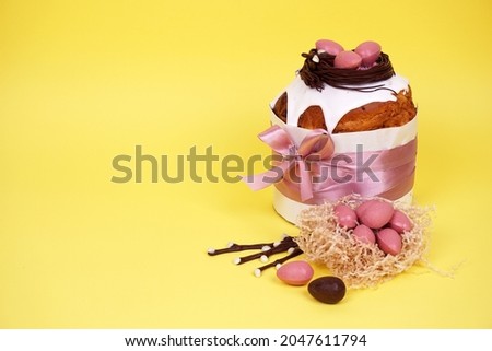 Beautiful Easter composition with Easter cake, chocolate eggs and a hare on a colored background.