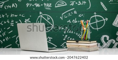 Education background concept. Stationery in jar On chalkboard with the Mathematical formula. Back to school banner design with Laptop.