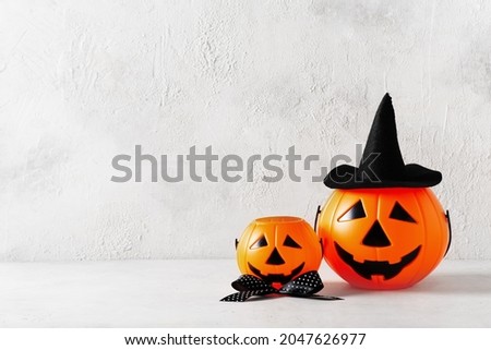 Halloween party concept with toy funny pumpkin in hat on white background, copy space, top view