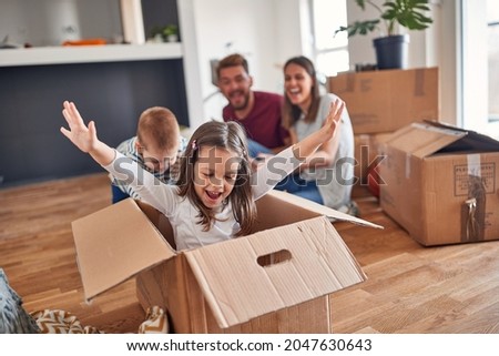 A young family is playing in a cheerful atmosphere in the new home they have just moved in. Home, family, moving Royalty-Free Stock Photo #2047630643