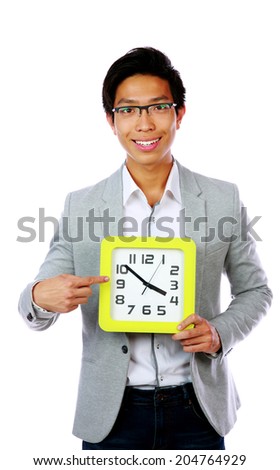 Business time. Business man holding and pointing to a big clock.