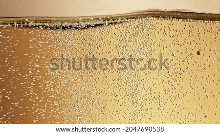 Close-up of champagne bubbles background with foam. Texture of beverages background. Royalty-Free Stock Photo #2047690538