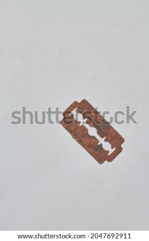 the unused razor is very rusty in the photo on a white background