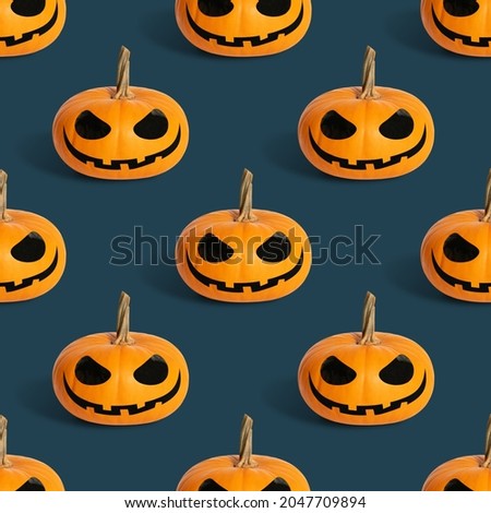 Seamless pattern with halloween pumpkin on a blue background. Jack o lantern head background. Halloween concept.
