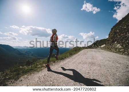 Young woman ultramarathon runner running at mountain top Royalty-Free Stock Photo #2047720802