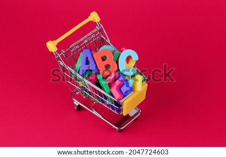 Letters in a shopping trolley on a pink background