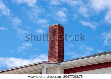 A red brick chimney covered with soot