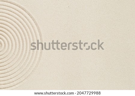 Lines drawing on sand, beautiful sandy texture. Spa background, concept for meditation and relaxation. Concentration and spirituality in Japanese zen garden. View from above. Royalty-Free Stock Photo #2047729988