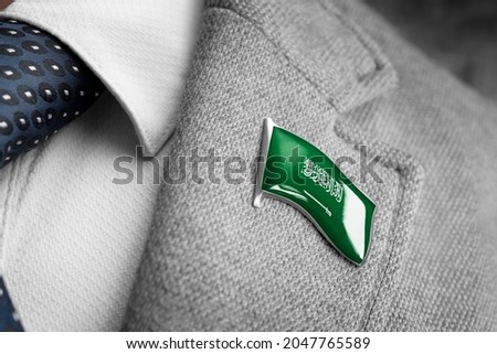 Metal badge with the flag of Saudi Arabia on a suit lapel Royalty-Free Stock Photo #2047765589