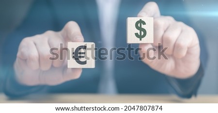 Hands holding cubes with dollar and euro icon. Currency concept. businessman's hands hold two wooden cubes with dollar and euro sign. businessman chooses euro or dollar signs Royalty-Free Stock Photo #2047807874