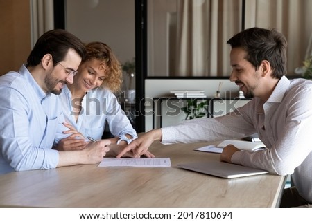 Happy couple of clients signing house buying, rent contract, insurance agreement, filling bank papers for mortgage, loan, meeting with lawyer, broker, realtor, real estate agent in office