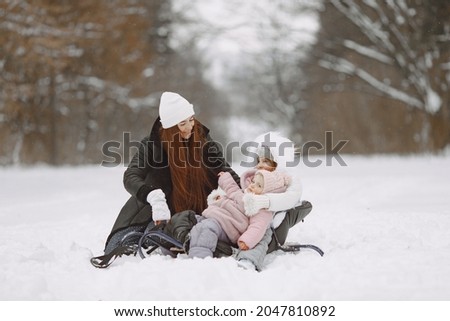Mother and child in winter clothes play in winter park
